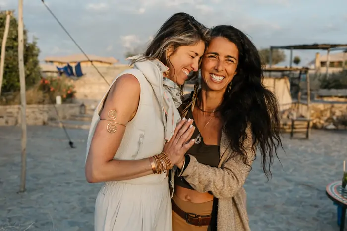 Brisa and Marcela laughing together at golden hour