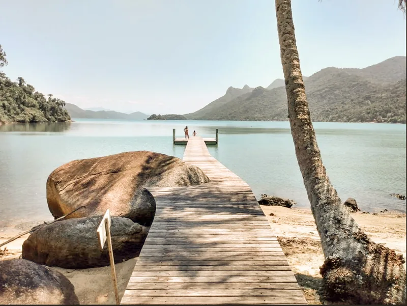 A wooden pier reaching into the calm bay