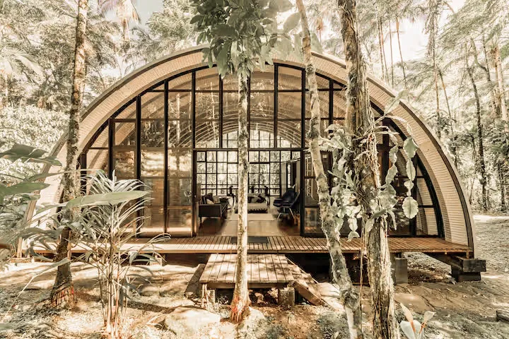An arched forest villa among the trees at Aldeia Rizoma